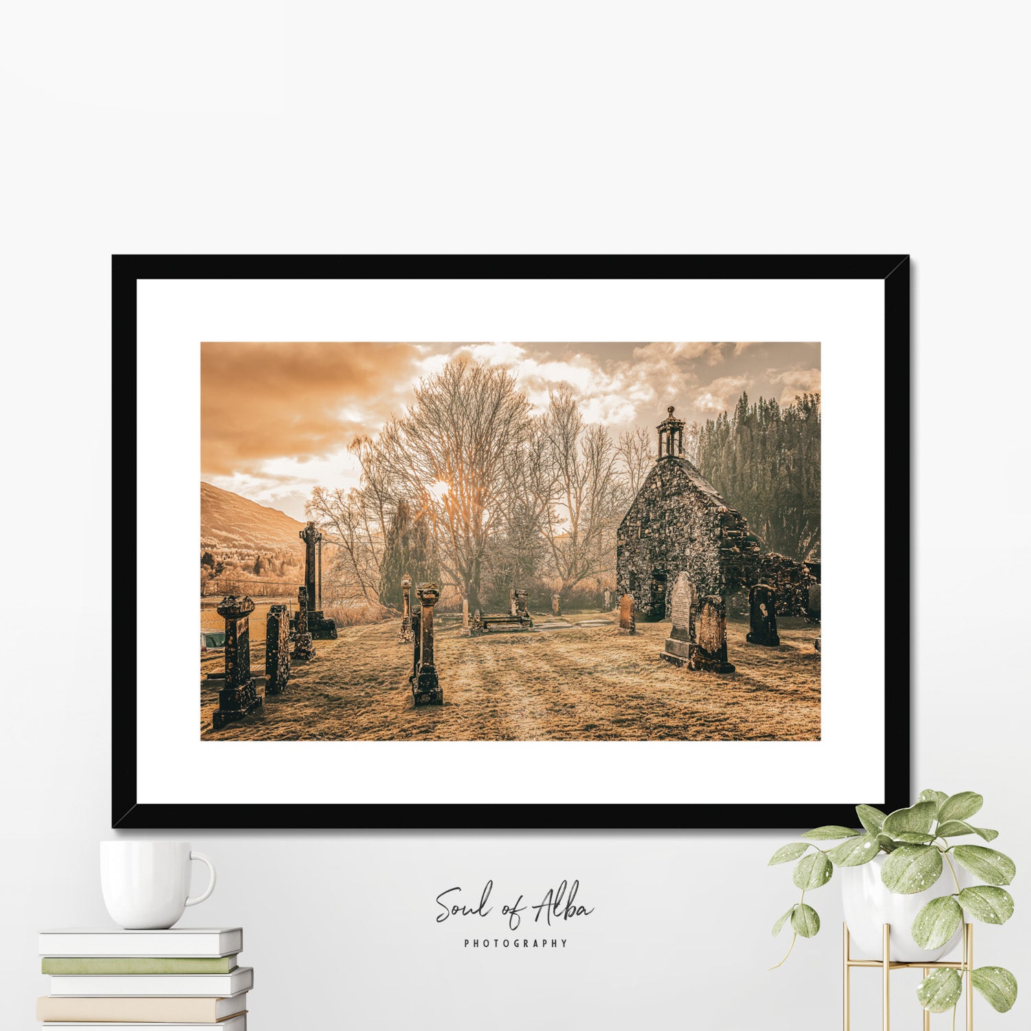 Framed fine art print of Balquhidder Kirk displayed in a modern interior, showcasing the historic church and graveyard in Perthshire.