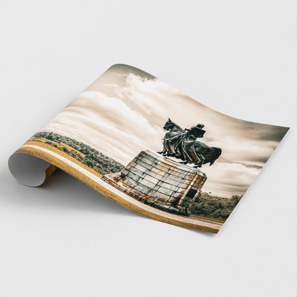 Close-up view of a rolled fine art print of the Robert the Bruce monument at Bannockburn. The shot highlights the rich bronze textures, weathered stone details, and high-quality finish of the photography print.