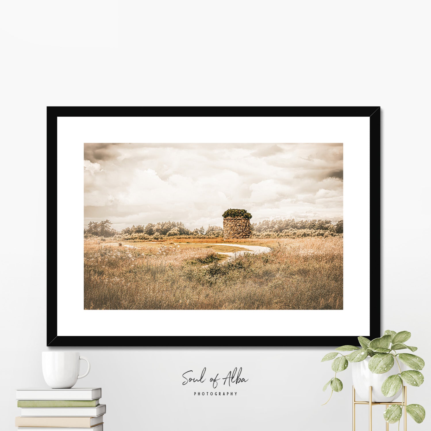 Framed print of Memorial cairn standing on Culloden Battlefield near Inverness, Scotland, beneath dramatic clouds and golden light.
